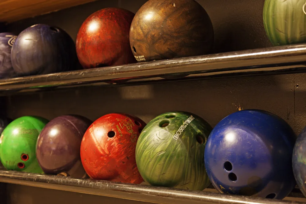Bowling balls showing 3 finger holes and finger grips.