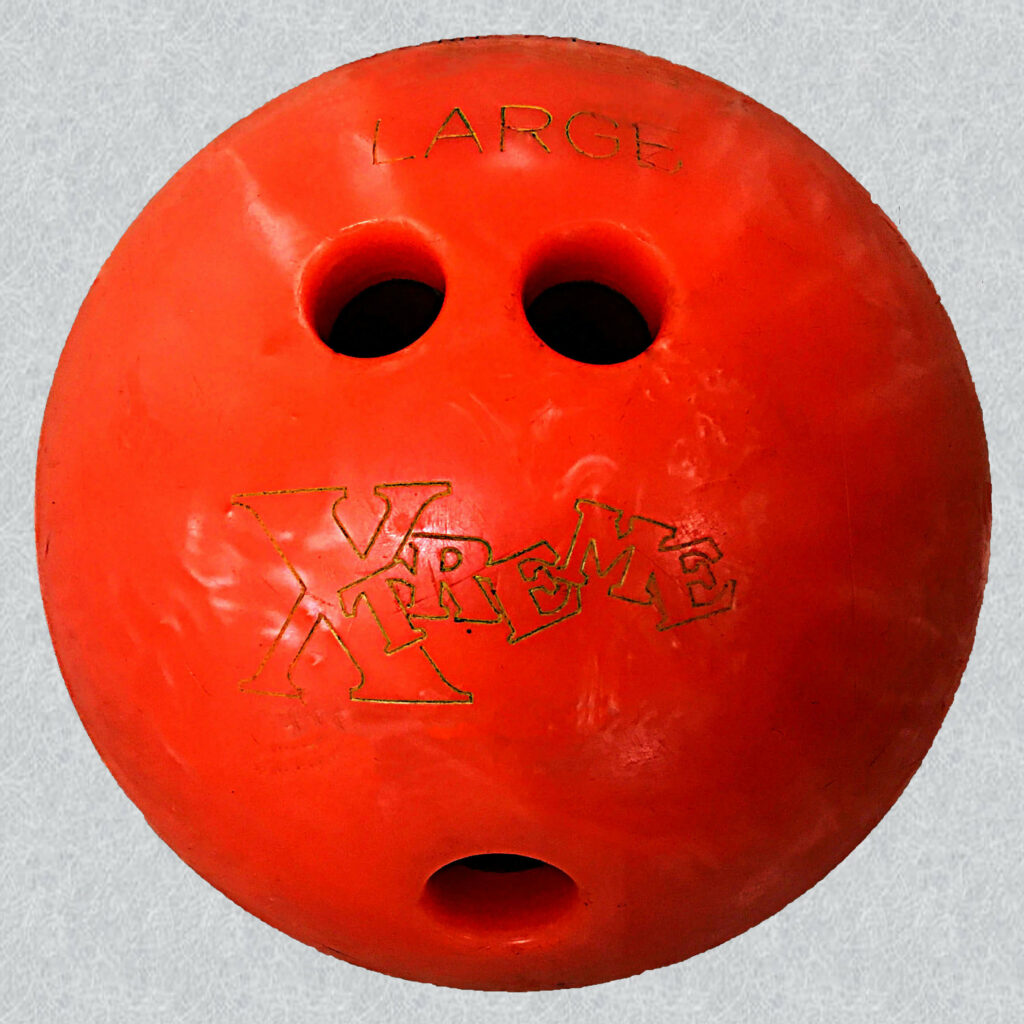 Orange rubber bowling ball with the word large engraved above the large finger holes.
