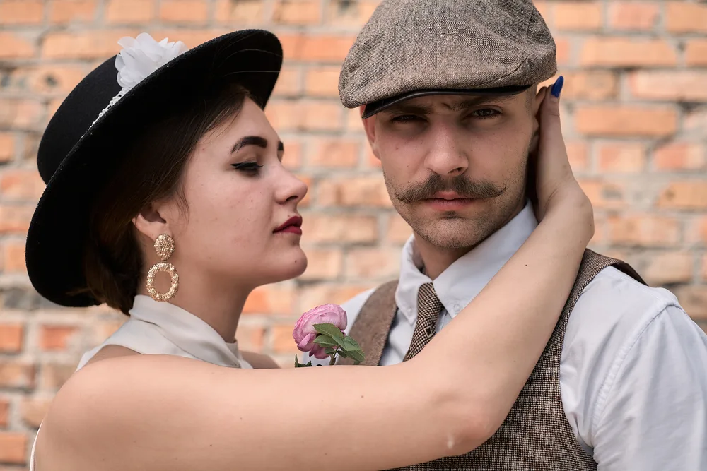 A woman and man dressed in vintage attire. In relation to bowling, they are overdressed.