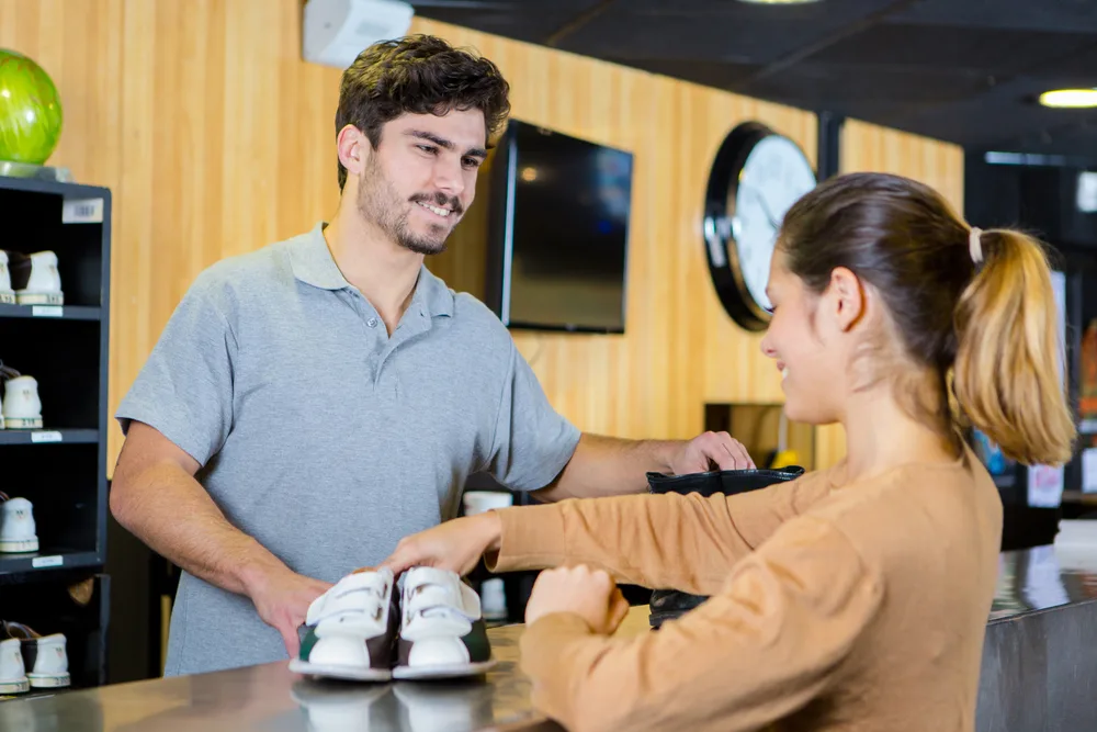 A lady renting shoes and looking for a good bowling ball leaves wondering why are bowling balls expensive in this economy.