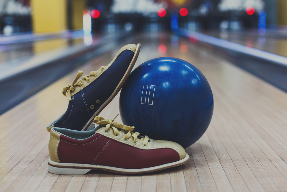 This image is of a bowling ball and pair of shoes. This image answers the question, what basic equipment is needed for bowling. The causal and professional bowler use reactive bowling ball instead of plastic balls.