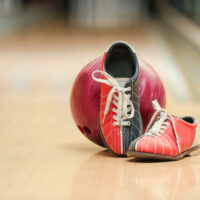 A pair of bowling shoes made from a leather-like microfiber material without a sliding sole or interchangeable soles.