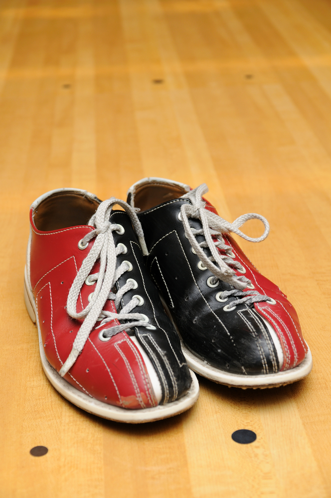 These are dual-colored, red, and blue bowling shoes on a bowling lane. The soles were cleaned and one direction brushing techniques were used to activate the sliding mechanism on the soles to get more traction.