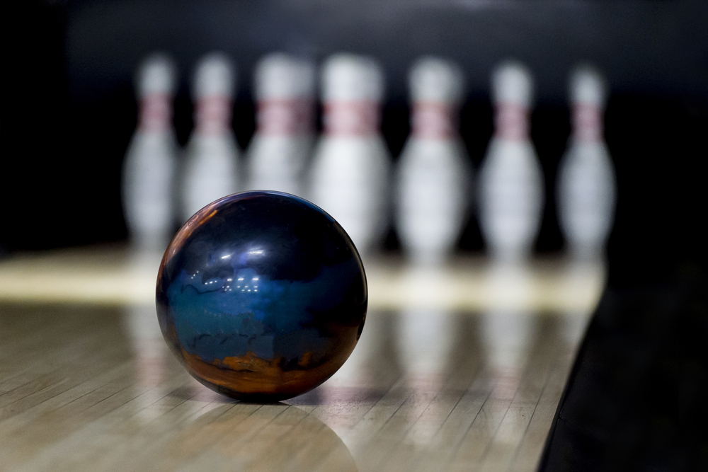 A 16-pound bowling ball, the best professional ball weight for ball speed and power, speeding down the lane.