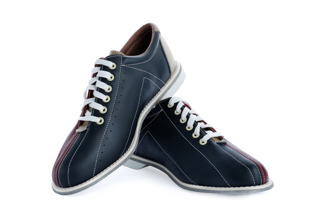 This image is of a pair of tri-colored bowling shoes with one shoe sitting on top of the other at an angle. As it relates to why do you have to wear bowling shoes, bowling centers require it for safety.