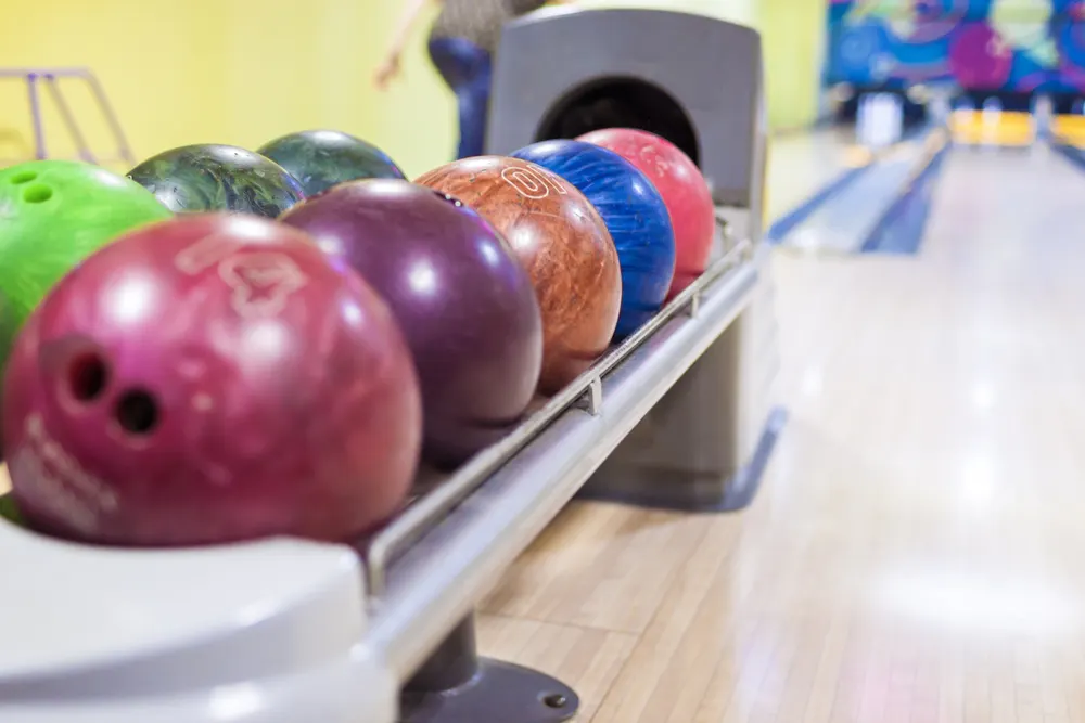 A bowling return machine with regulation bowling balls that aren't the same weight or material.