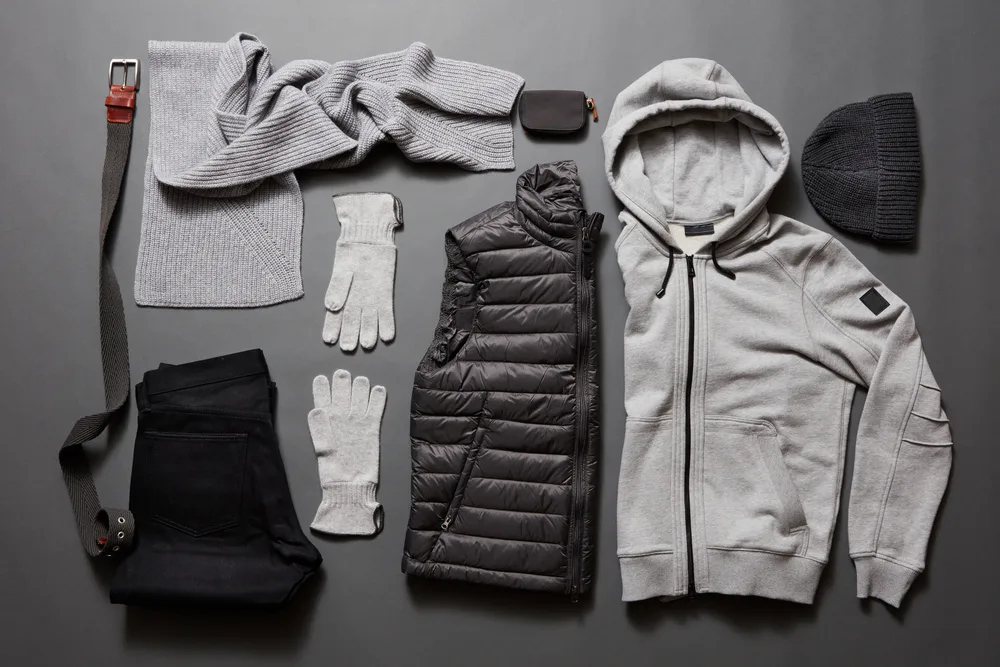 Gray winter hoodie, black wind breaker, gray gloves, black knit hat, belt, and gray scarf. To make the outfit pop, you can layer a white tee or any basic tee underneath.