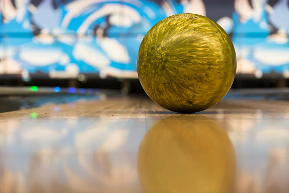 A golden bowling ball on the bowling lane is the right bowling ball to use.
