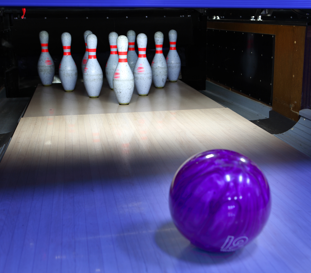 The purple 12 pound bowling ball aimed at the awaiting headpin was released with a straight bowling technique to achieve a strike.