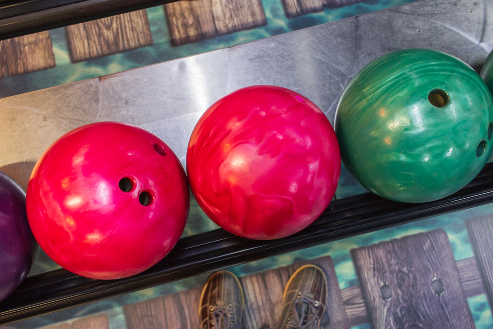 A house ball or your own bowling ball is sufficient for bowling; like the pink and green balls pictured.