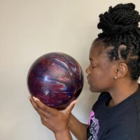 A woman sniffing a scented bowling ball.