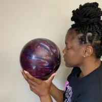 A woman sniffing a scented bowling ball.