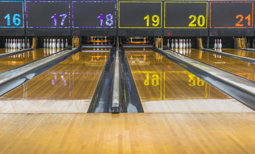 Six lanes are visible with colorful lane numbers and the pinsetter machine resets two of them with an automated system, so there is no manual pin resetting after every roll.