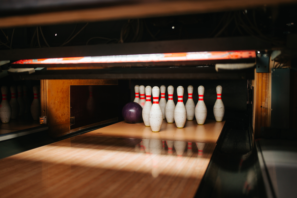 A single purple bowling ball in a ten pin bowling game is as a league faces opponents in a scheduled competition where special prize funds accumulated.