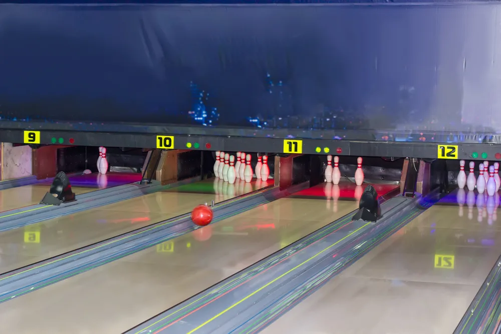 The image shows a red ball in the gutter, leaving an open or blank frame and three pins are remain.