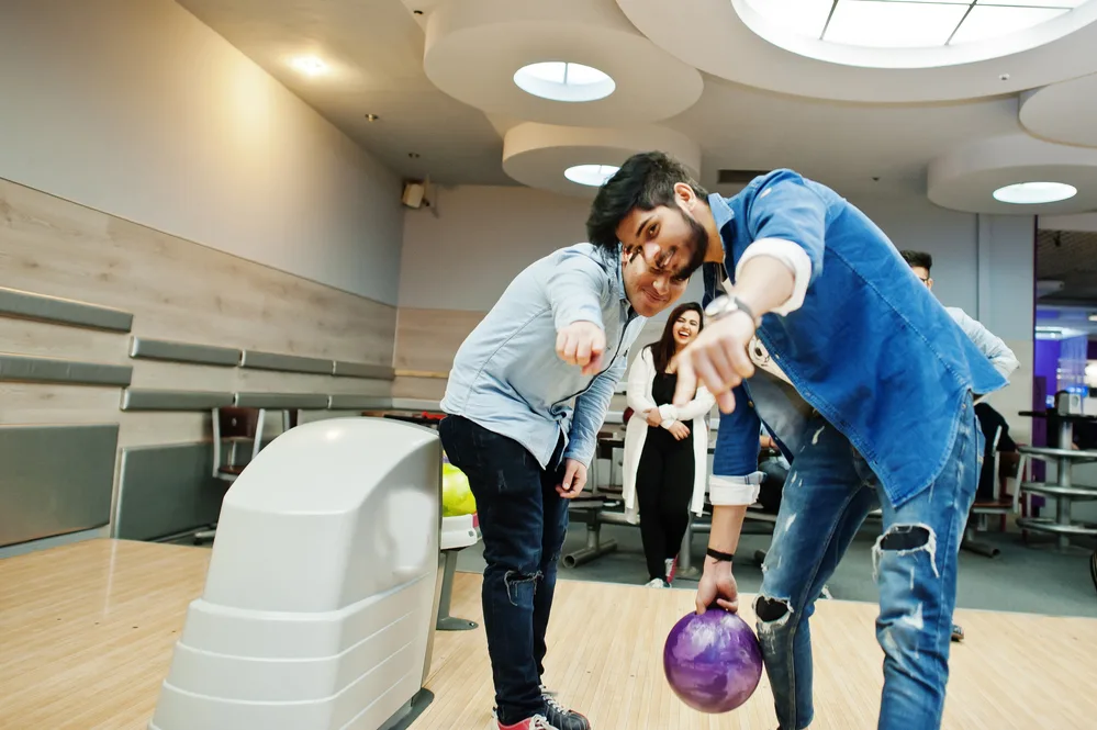 The guy in the blue shirt and denim jeans decided to take lessons because he wants to join a bowling league.