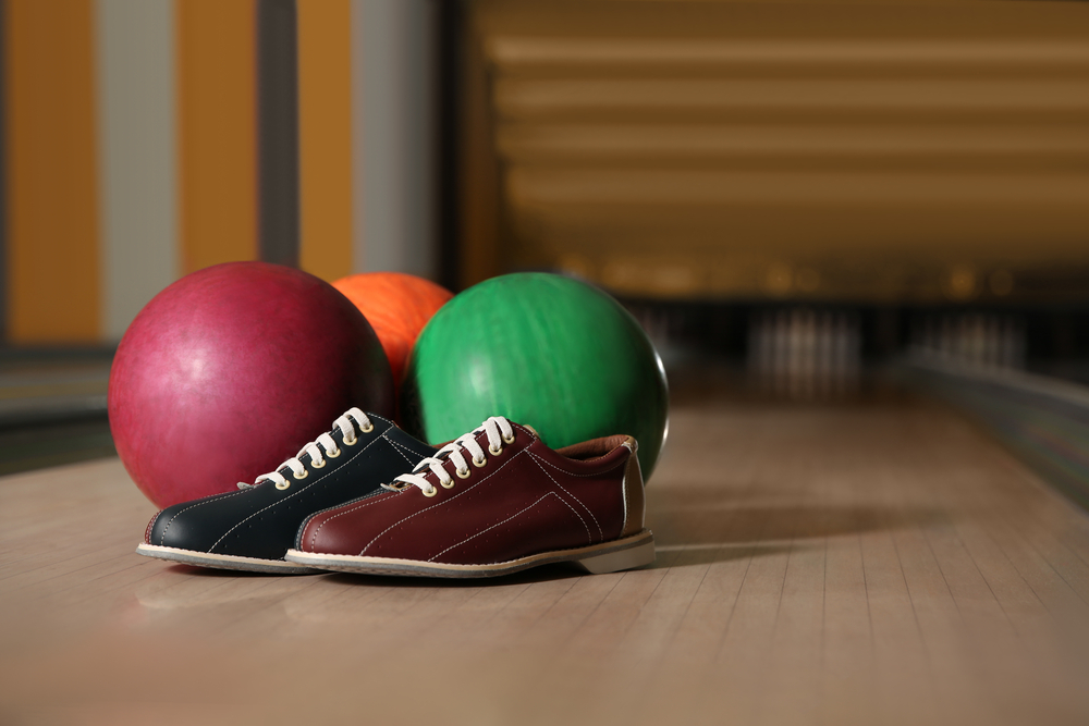 Shoes and reactive resin balls on the bowling lane make after a bowling game.
