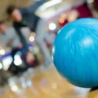 A professional bowler, who is cheered on by teammates, uses their own ball instead of a house ball to secure the win.