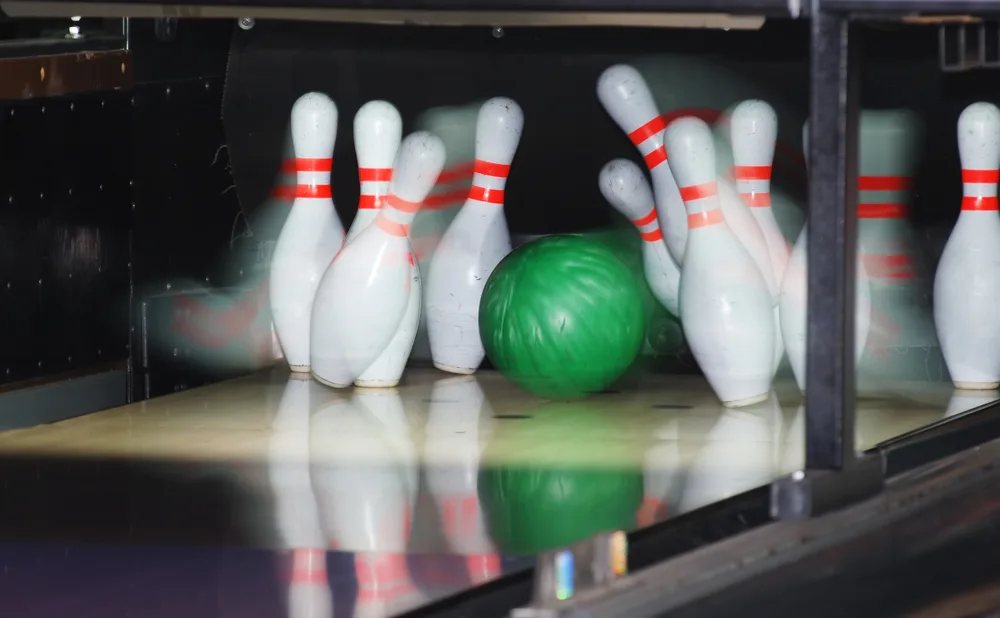 In the first frame, the bowler released their green strike ball down the lane and created pin action.
