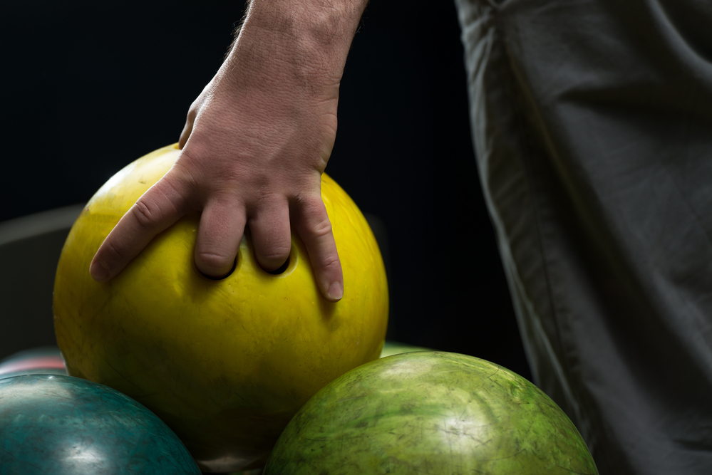 The yellow bowling ball is plastic or polyester and urethane balls are not typically found at the bowling alley.