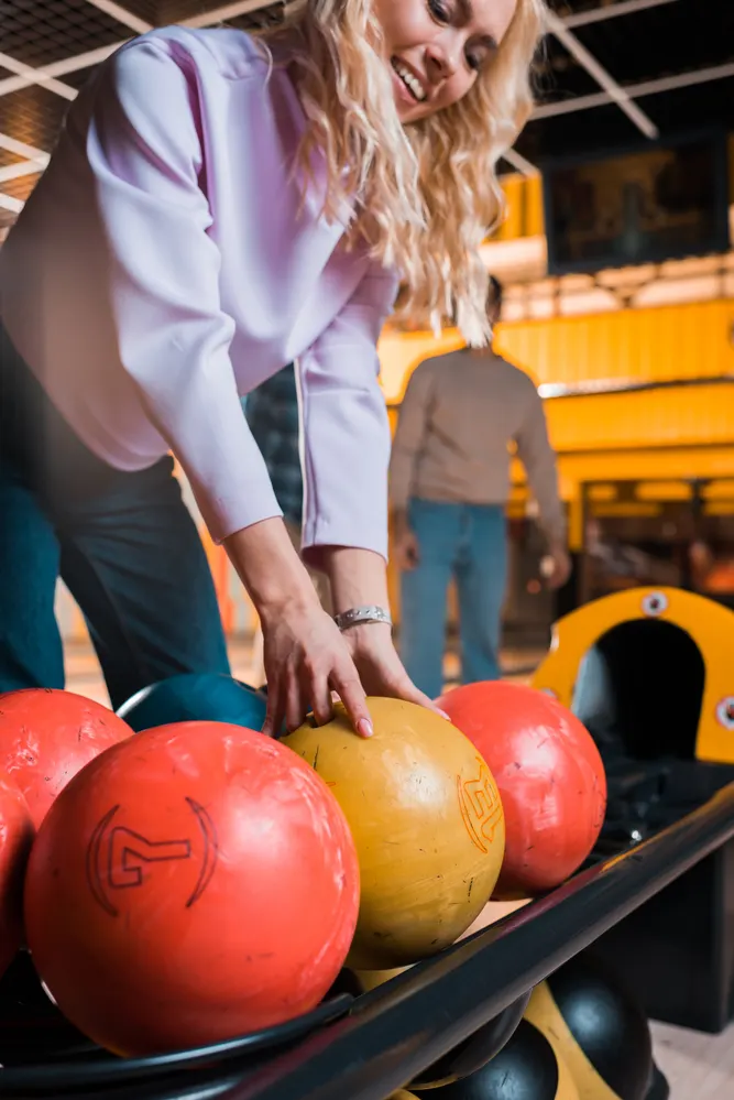 Lady in a pink sweater, picking up the yellow ball, spoke with her doctor first, because she planned on bowling during pregnancy.