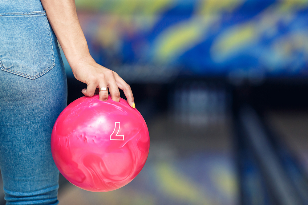 The lady in jeans chose the lighter ball so she is safe while bowling.