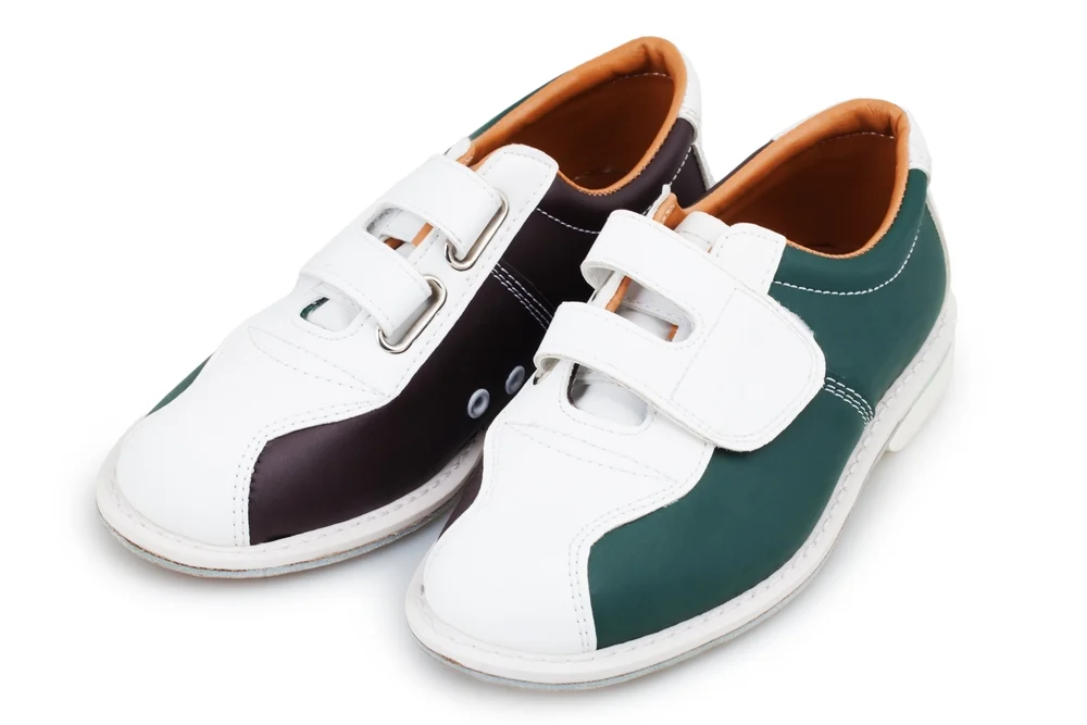 Tri-colored bowling shoes, brown, green, and white, with velcro straps, do not need resoling because the bowler crossed the foul line.