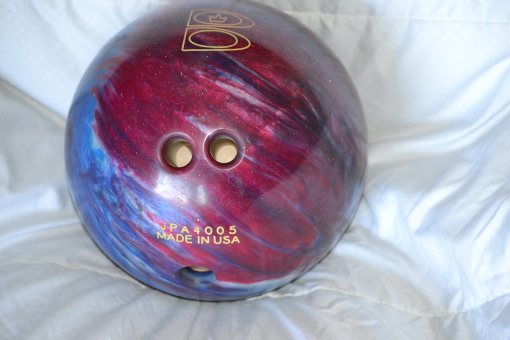 Red and blue reactive resin brunswick t zone bowling ball on a white background.