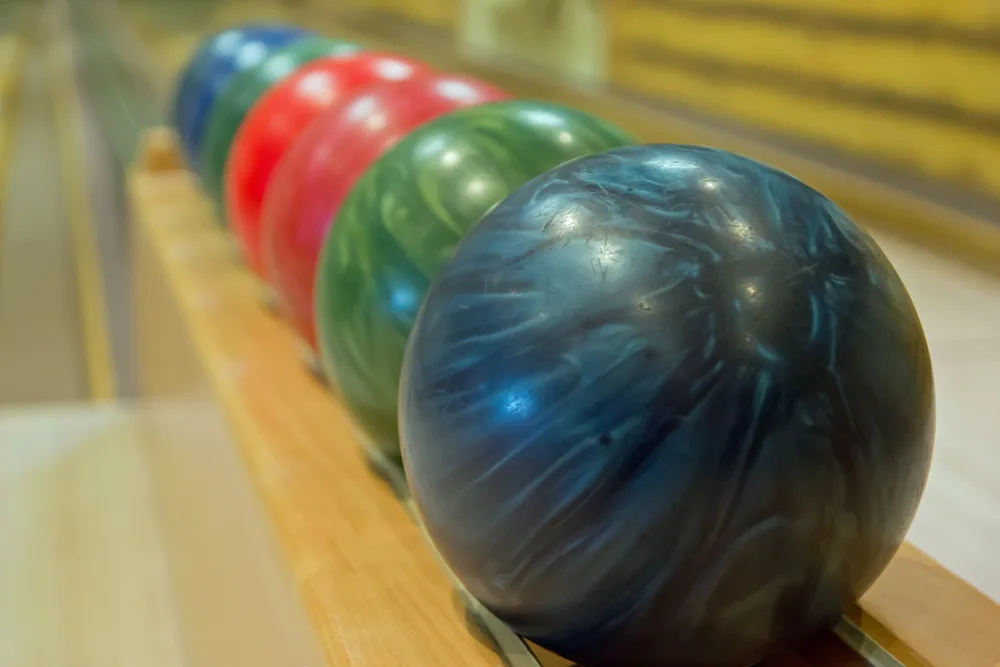 New bowling ball sitting on the shelf for a custom drilling services will include span and hole sizes.