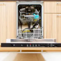 After soaking inside, an open dishwasher with a bowling ball goes through the heated dry cycle.