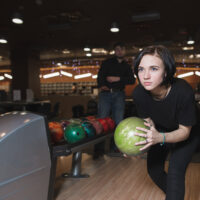 A beautiful young girl that hasn't thrown a gutter ball is seeking the toughest pin count with a 299 final score.