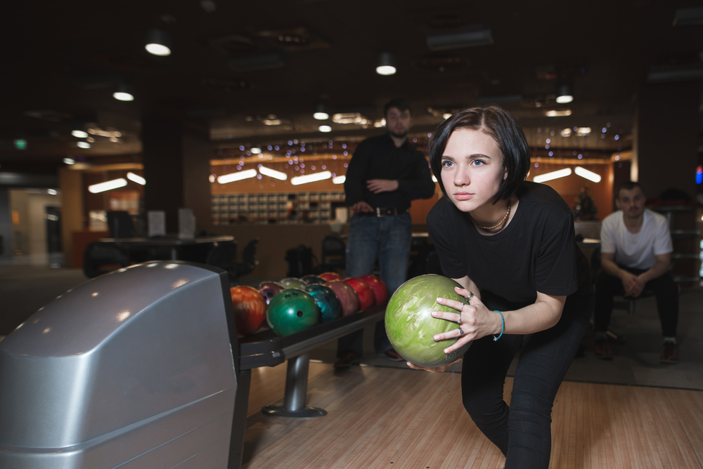 A beautiful young girl that hasn't thrown a gutter ball is seeking the toughest pin count with a 299 final score.