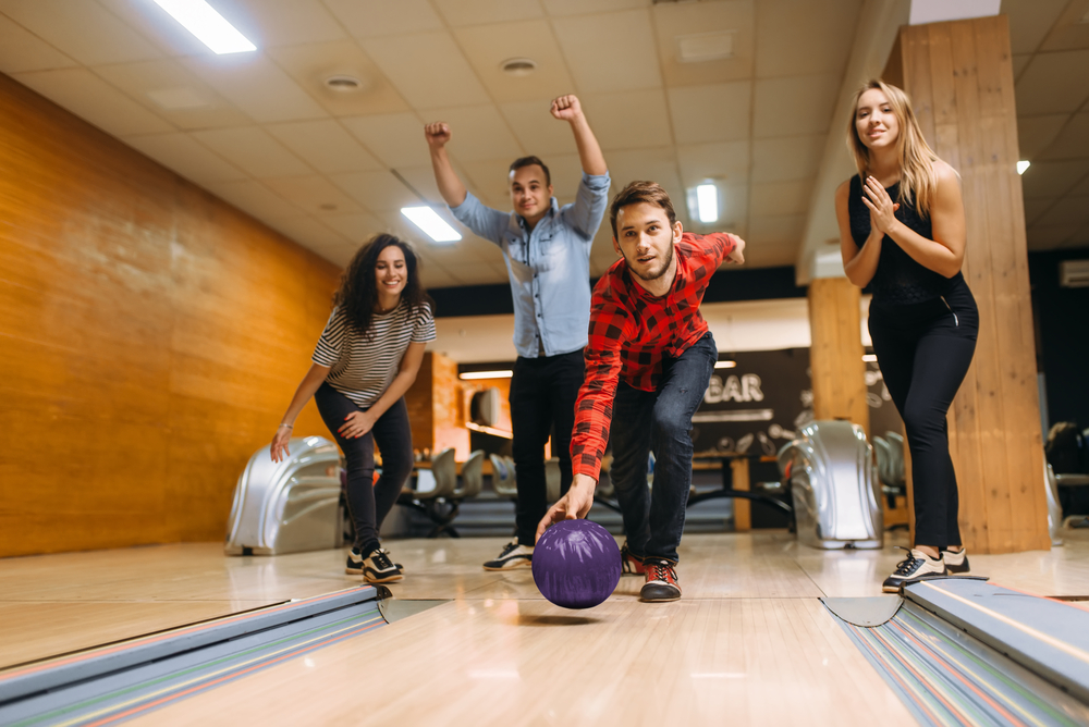 Male bowler playing a game with his neighbors when he accidentally crosses the foul line while bowling.