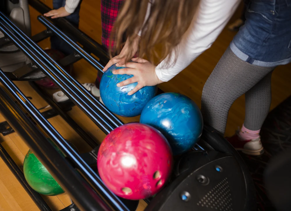 The children are using the same ball as their neighboring bowler and that's not good bowling etiquette.