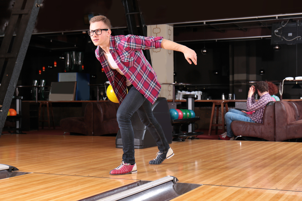 The guy in the plaid shirt bowled a perfect game, knocked down all the standing pins.