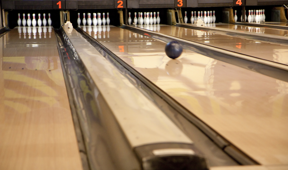 A ball rolls down a wooden bowling lane at super bowl entertainment and bowling center in houston, texas.