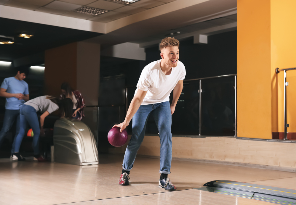 A young male that is a strong baseball batter in the major leagues is using bowling as an off-season exercise.