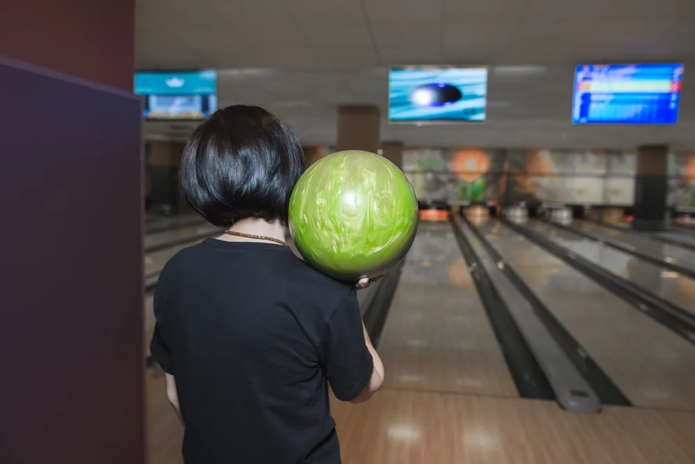 The back of a girl prepares to throw her second ball during a single frame after she just barely missed a strike.
