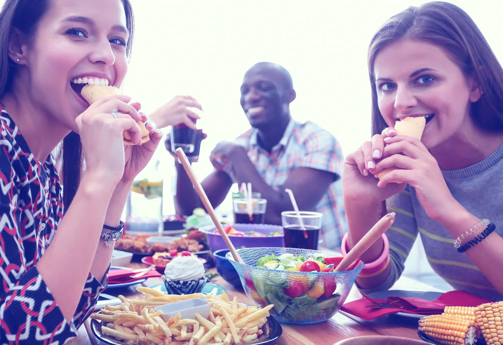 Friends gathered on a friday night enjoying food and drinks from the bar menu.