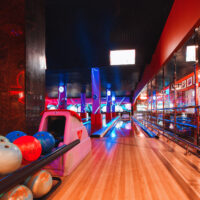The bright and colorful lights create a fun and memorable bowling alley experience.
