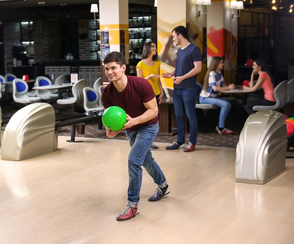 The bowler in the burgundy shirt practiced rolling toward the same arrow each time.