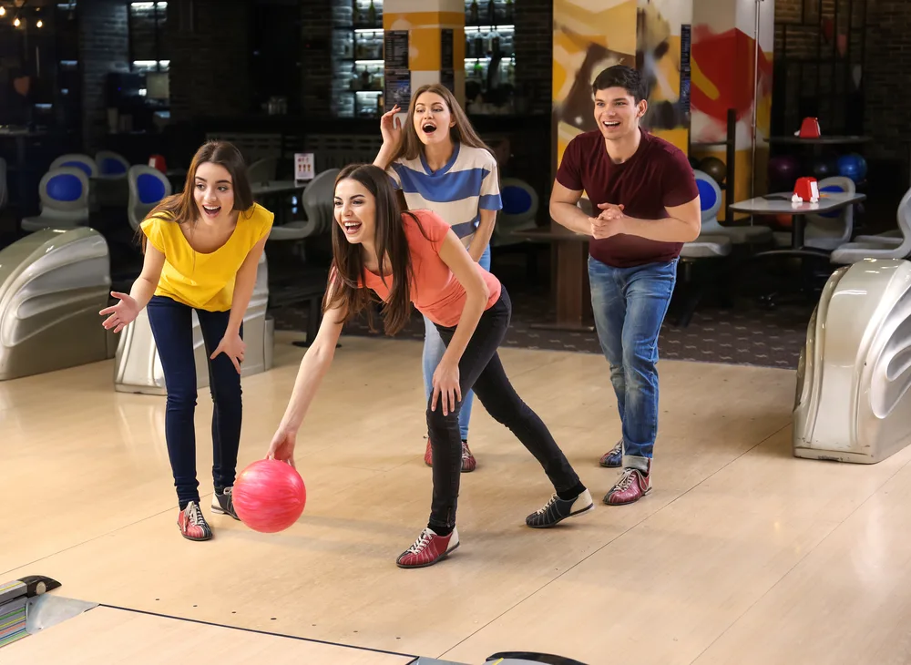 Bowling Strategies: Tips And Techniques For Better Bowling 1 The bowler in the orange shirt is stepping with her left foot.
