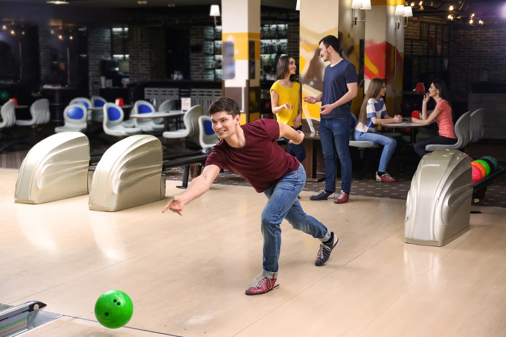 The bowler in teh burgundy shirt has bowled an entire game by himself.