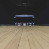 Tan colored bowling alley lanes will not crack when the bowling ball is dropped on it.