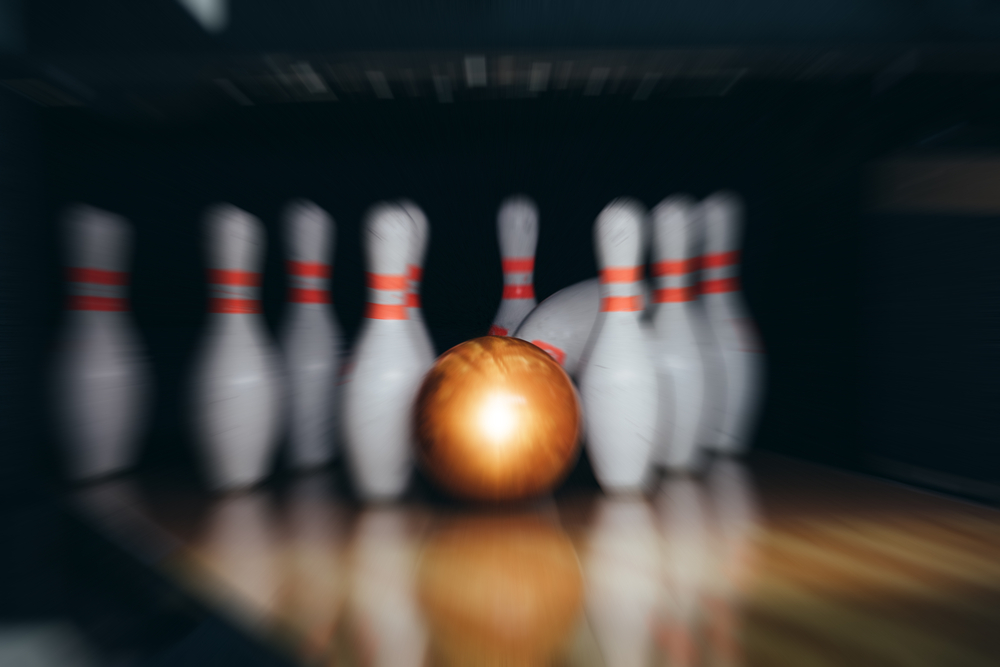 The orange bowling ball rolled down the bowling lane.
