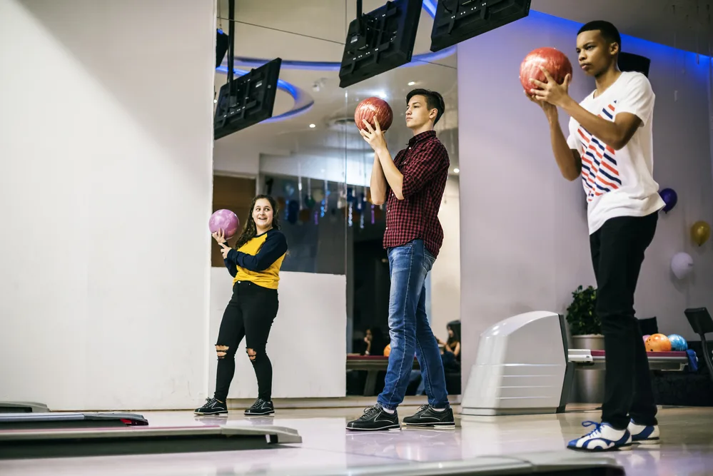 The team of the girl and two guys are wearing different bowling shoes.