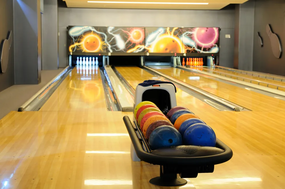 The automated pinsetter machine sweeps the knocked down pins and ball into the ball pit.