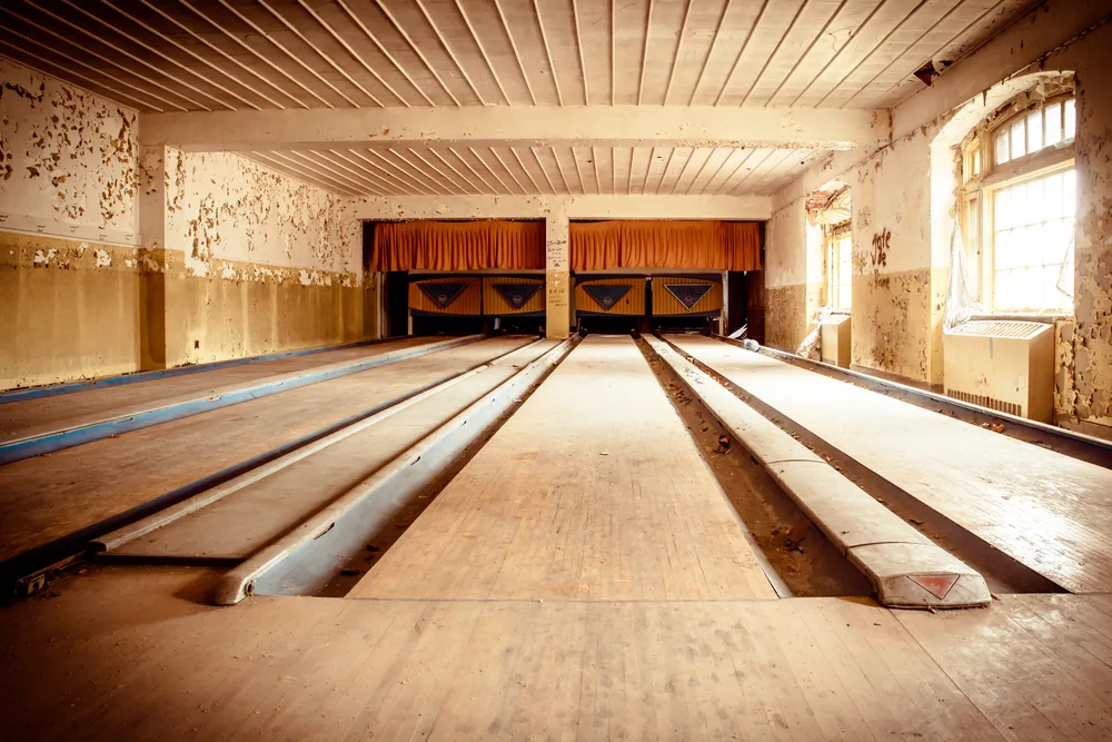 Inside of dusty, real life bowling alley with paint chipping off the walls and tattered floor boards.