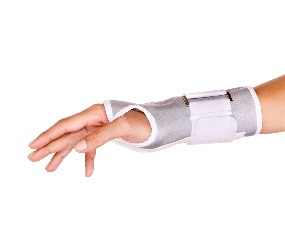 A woman's arm in a grey and white trimmed wrist brace.