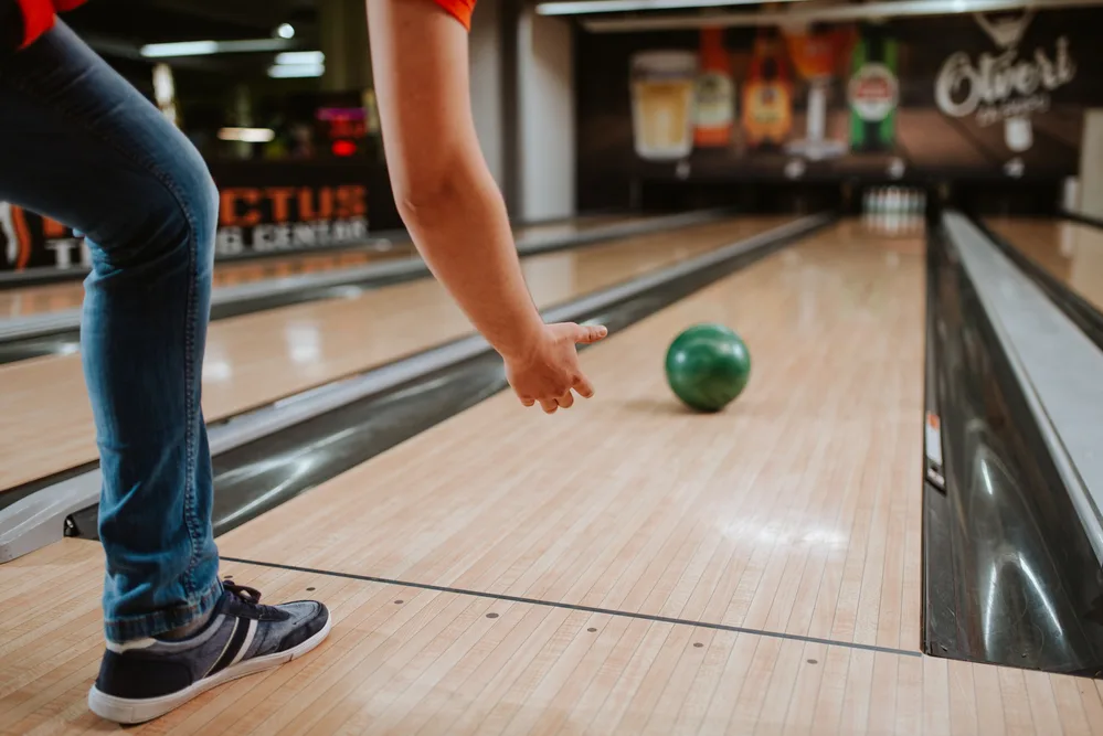 The bowler in the black and red shirt used the thumb hole to bowl the green bowling ball.